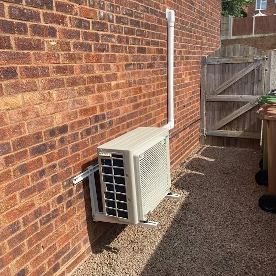 Outdoor domestic air-conditioning unit mounted on a brick wall