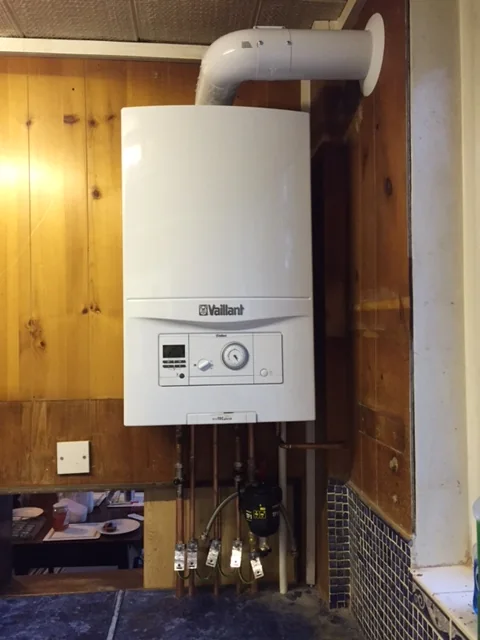 Example of wall-mounted vaillant boiler with flue and heating pipework for boiler customers in Cumbernauld