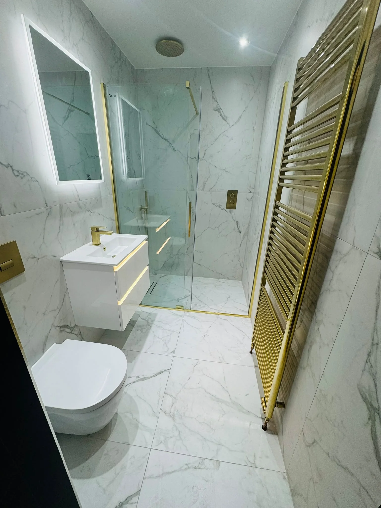 Completed marble bathroom with gold shower fittings