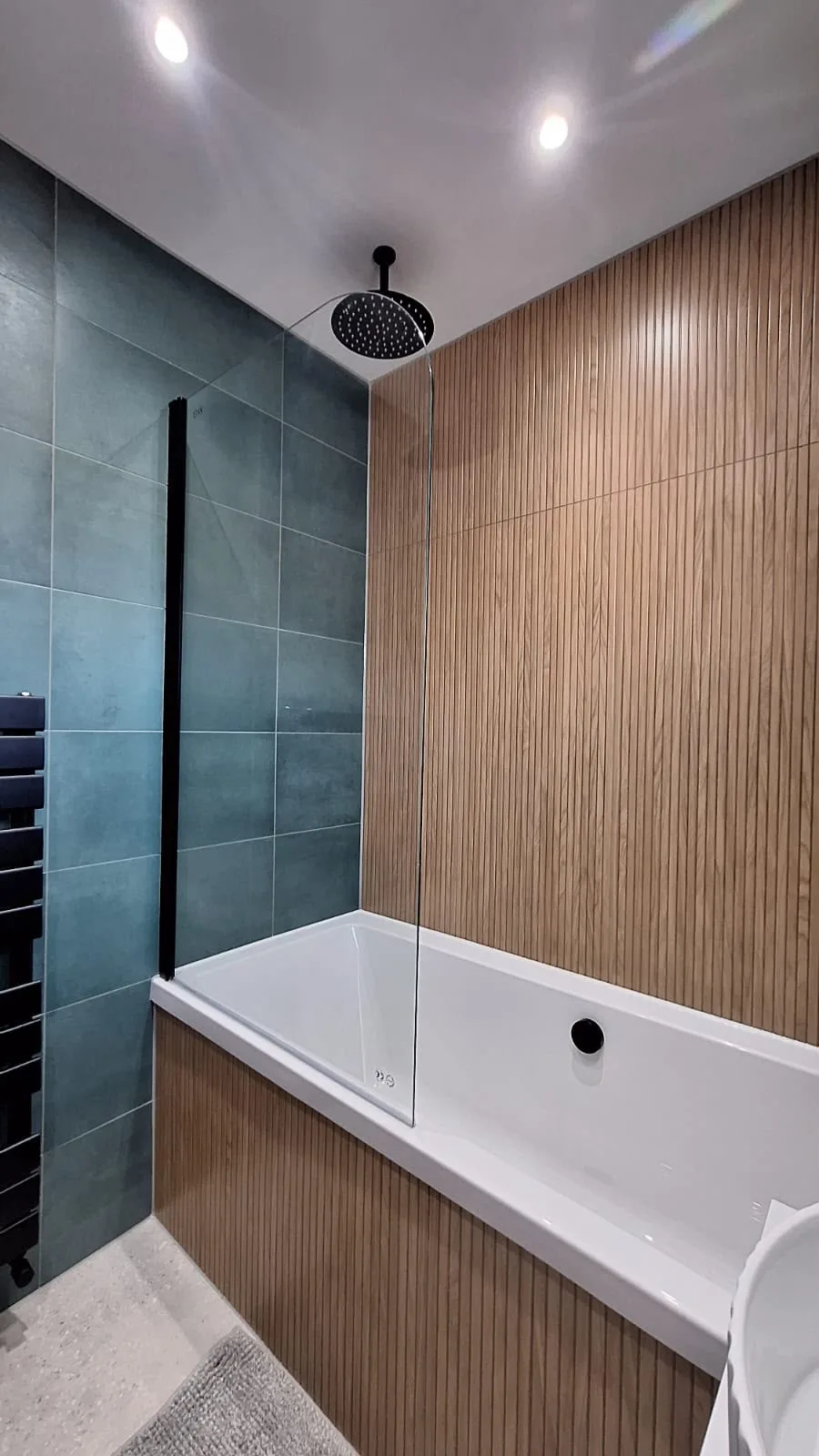 Bathroom with wood-effect bath panelling, rainfall shower and black fittings